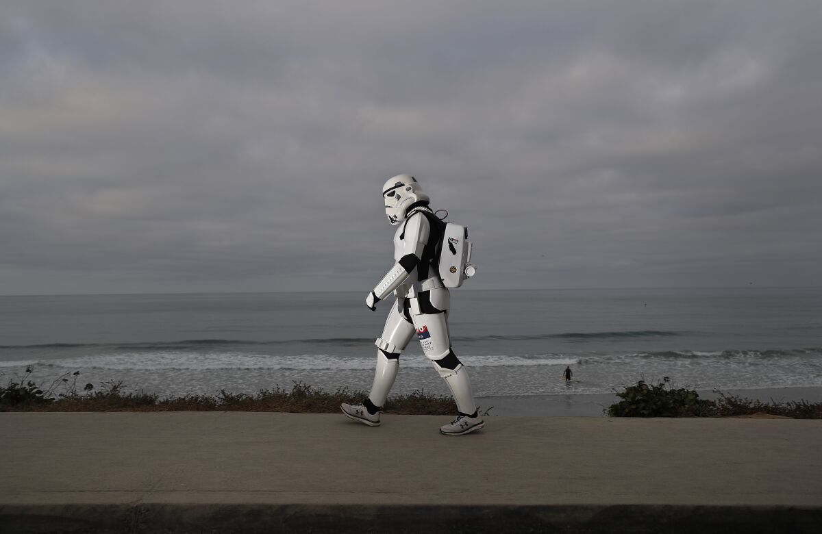 Jeffry Priela, 38, of Carlsbad, walks down Highway 101 during a fundraising 10K "ruck" in his Star Wars stormtrooper armor.