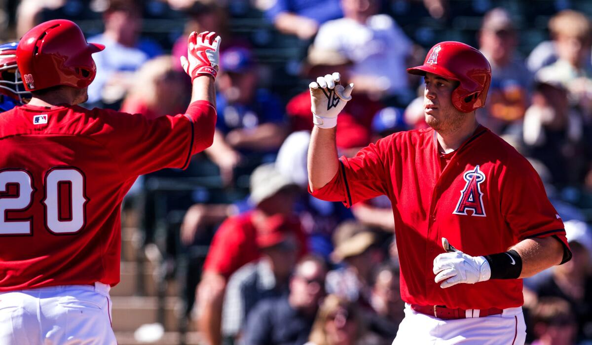 Angels first baseman C.J. Cron, being congratulated by teammate Matt Joyrce after hitting a home run March 10, hits his third homer of the spring Sunday against the Reds.