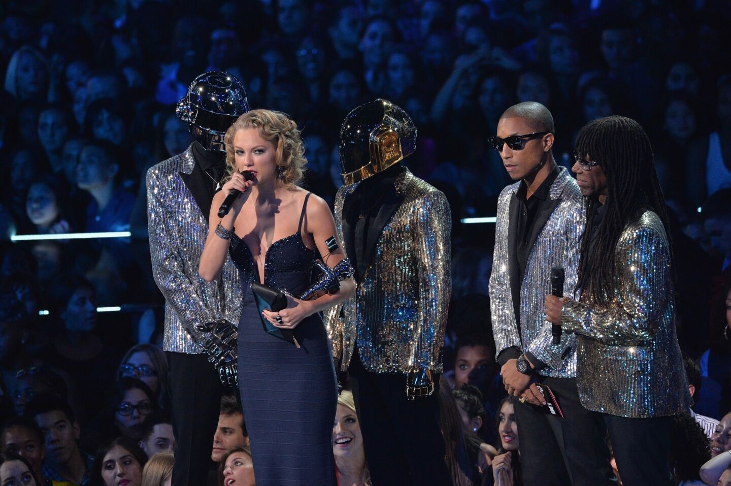 Taylor Swift accepts an award presented to her by Daft Punk, Pharrell Williams and Nile Rodgers.