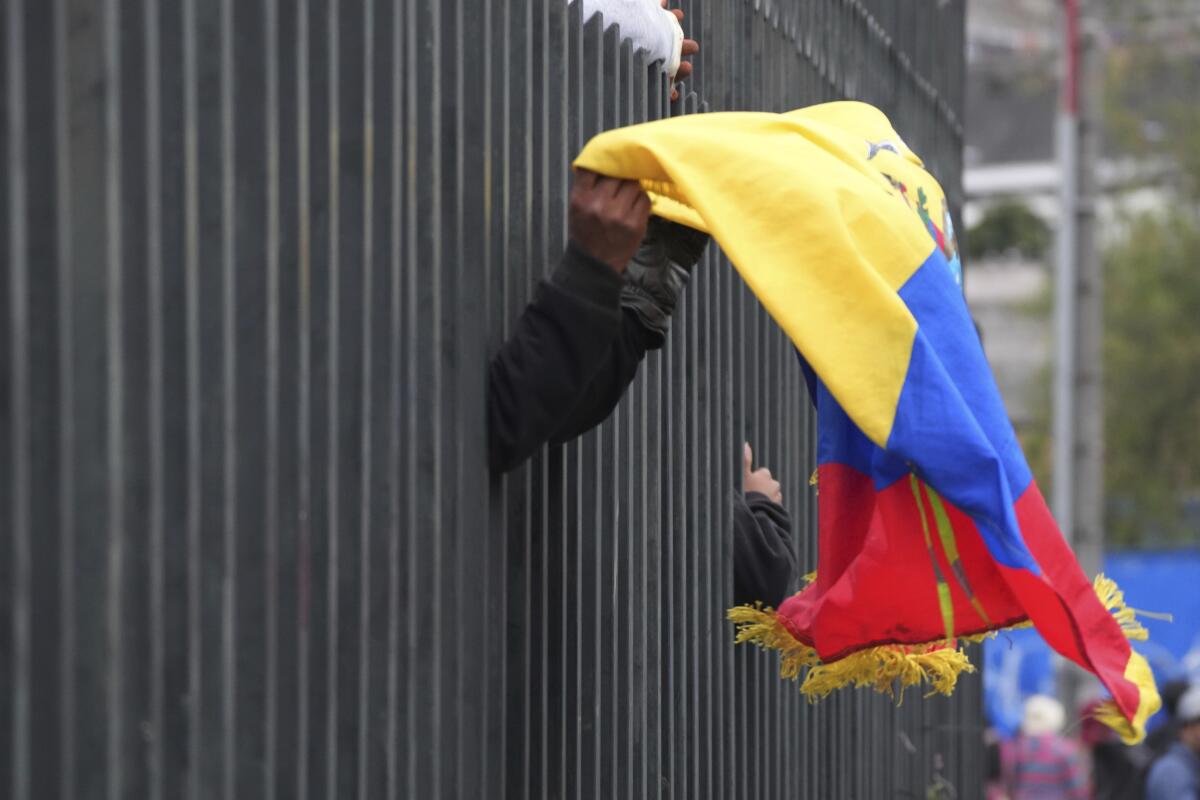 Un manifestante indígena lleva una bandera ecuatoriana dentro de la Casa de la Cultura en Quito 