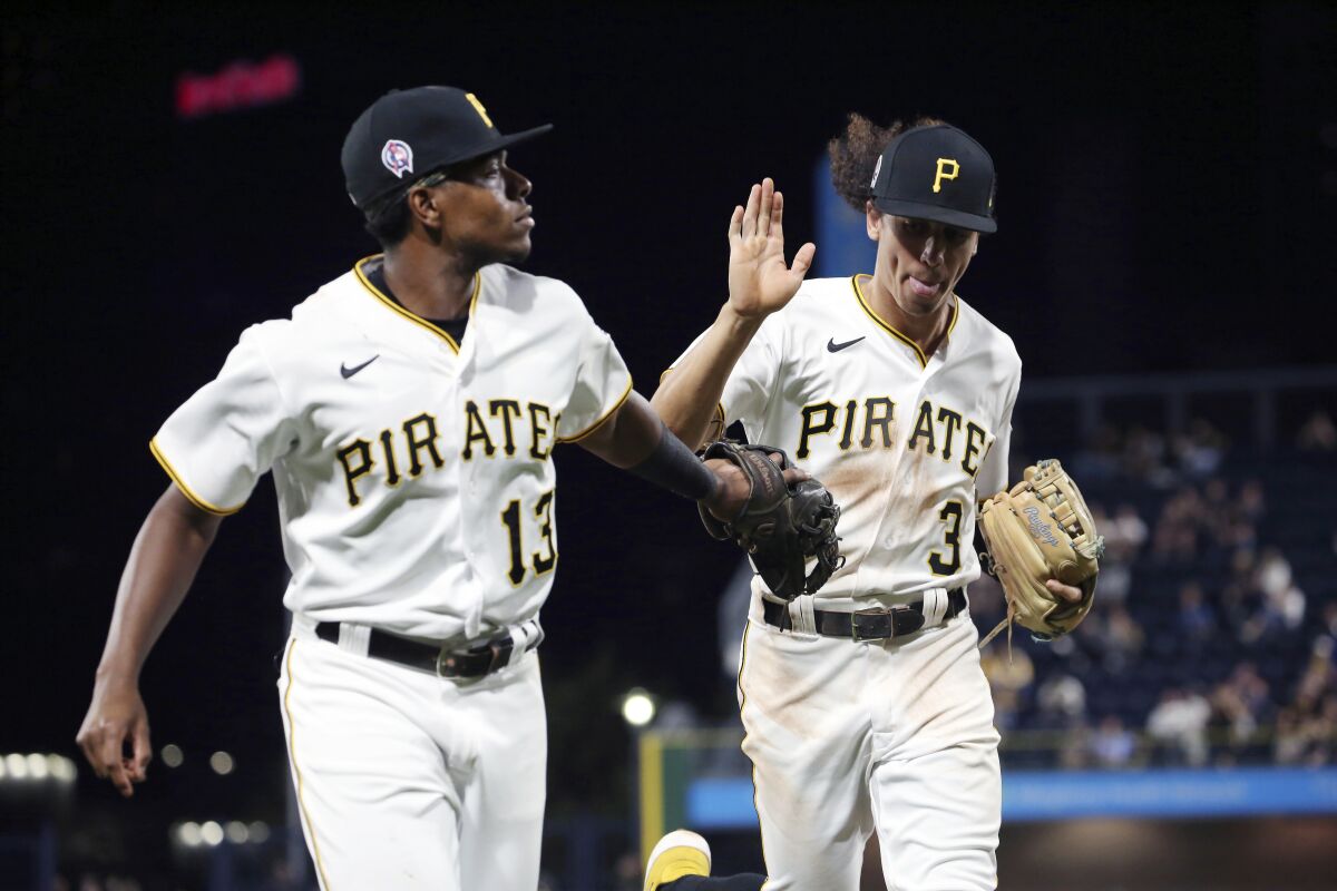 Pittsburgh Pirates third baseman Ke'Bryan Hayes (13) and Pittsburgh Pirates shortstop Cole Tucker (3) high-five in the fifth inning of a baseball game against the Washington Nationals, Saturday, Sept. 11, 2021, in Pittsburgh. (AP Photo/Rebecca Droke)