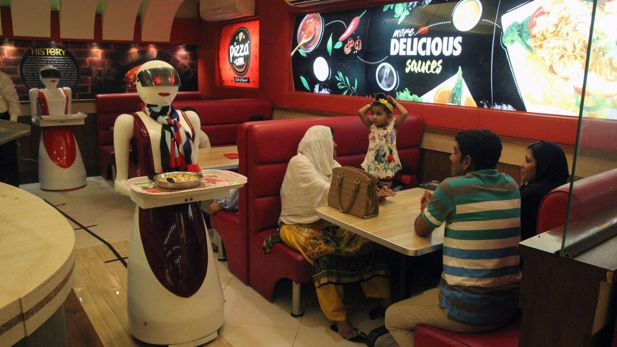 A robot waitress delivers food at a pizza restaurant in Multan, Pakistan, on July 4.