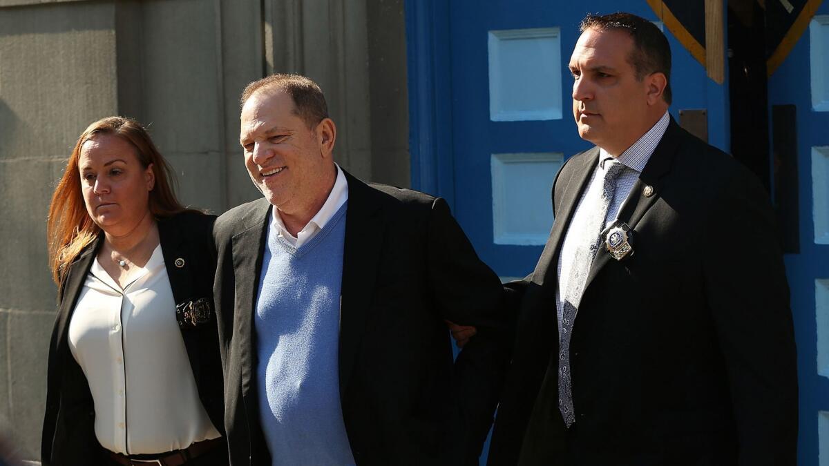Harvey Weinstein is led out of the New York Police Department's First Precinct in handcuffs after being arrested and processed on charges of rape, committing a criminal sex act, sexual abuse and sexual misconduct in May.
