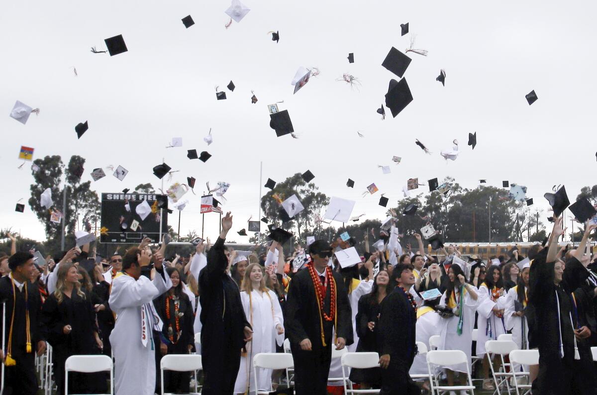 Graduates throw their caps into the air at the end of the Huntington Beach High School commencement ceremony on Wednesday.