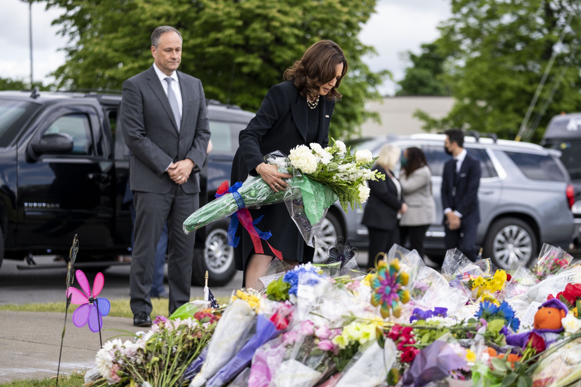 Kamala Harris places flowers at a memorial.