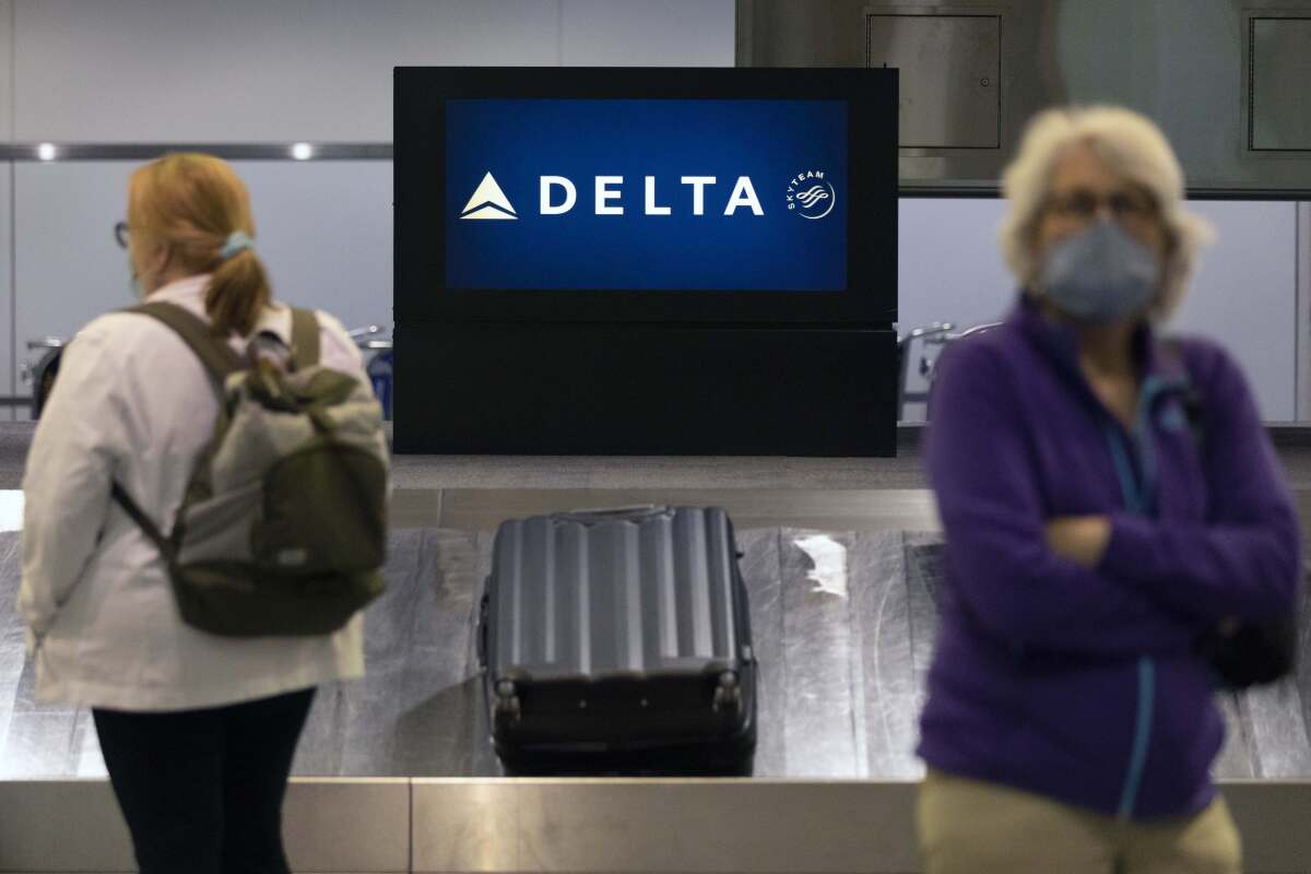 Passengers wait for luggage in the arrival area of Delta Air Lines, Monday, July 12, 2021, at Logan International Airport in Boston. Delta Air Lines is reporting a $1.2 billion profit for the third quarter, thanks in large part to federal aid to help the industry get through the pandemic. Delta said Wednesday, Oct. 13, that travel demand is improving after flattening out in late summer, when coronavirus cases spiked in the U.S. (AP Photo/Michael Dwyer)