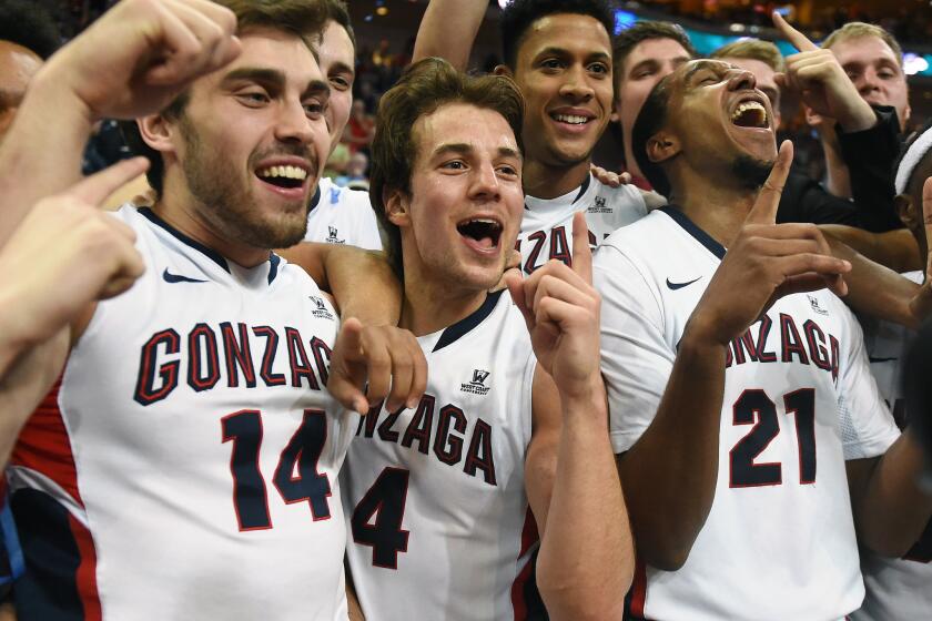 Gonzaga's Connor Griffin (14), Kevin Pangos (4) and Eric McClellan (21) celebrate after beating Brigham Young, 91-75, to win the West Coast Conference championship.