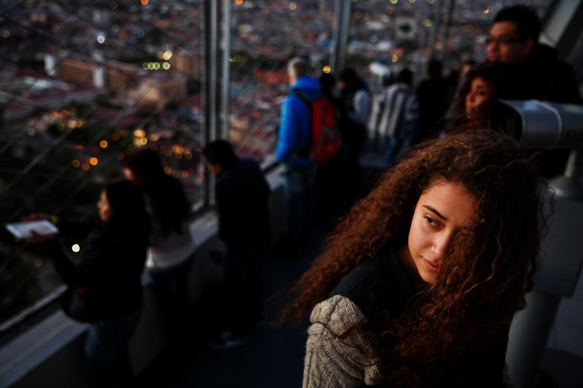 Mariana Garcia Vgalde, 15, watches the sun set into the horizon on the observation deck of Torre Latinoamericana in Mexico City.