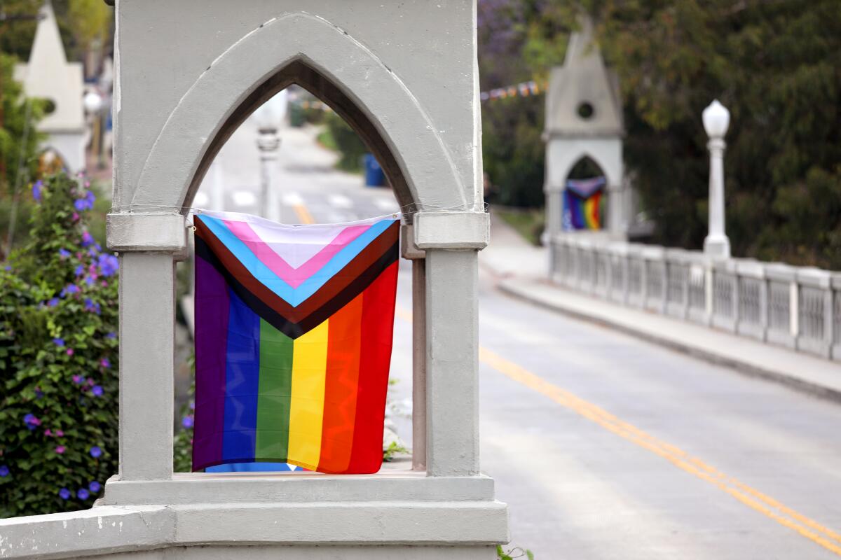 Pride flags hanging from a bridge