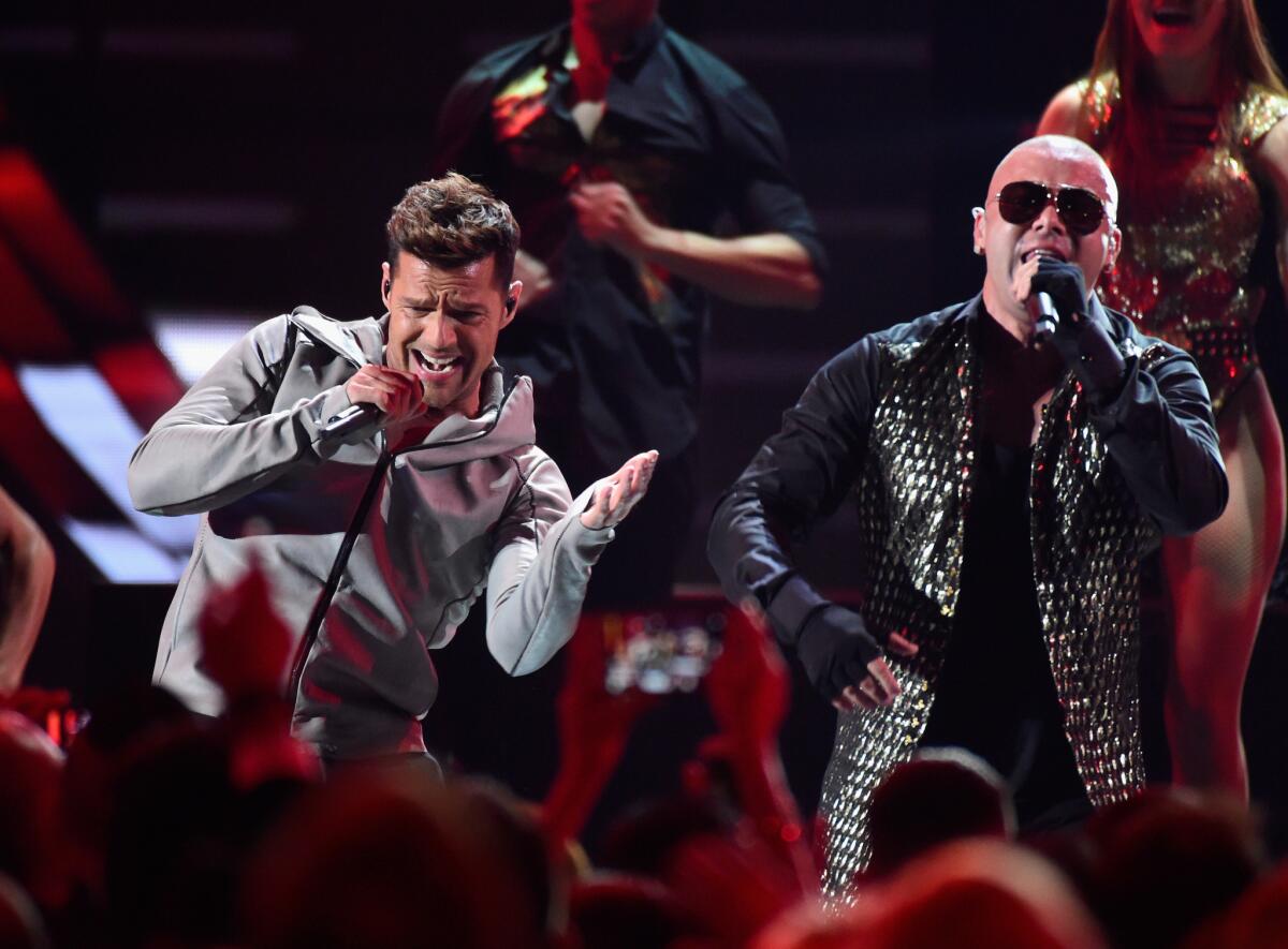 Pop star Ricky Martin, left, and reggaeton star Wisin -- both of whom hail from Puerto Rico -- perform their song 'Que Se Sienta El Deseo' during the 16th Latin Grammy Awards.