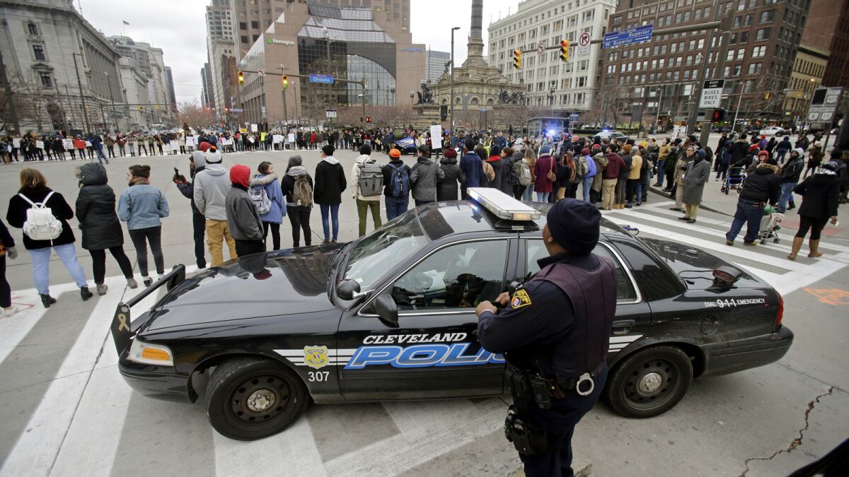 Cleveland officers watch demonstrators last month during a protest over the police shooting of 12-year-old Tamir Rice.