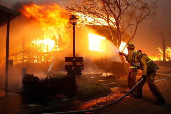 Firefighters put water on a fully engulfed home at the Oakridge Mobile Home Park near Glenoaks and Foothill boulevards in Sylmar.