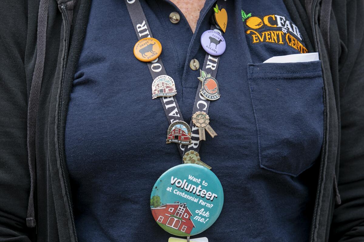 Huntington Beach resident Barbara Livingston displays a lanyard with pins showing her years of service. 