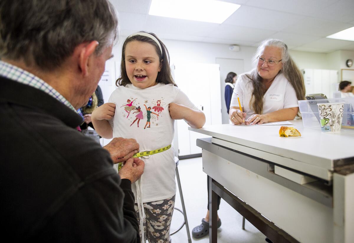 John Connolly, left, measures Hannah Krikorian's waist Friday during a Pageant of the Masters. 