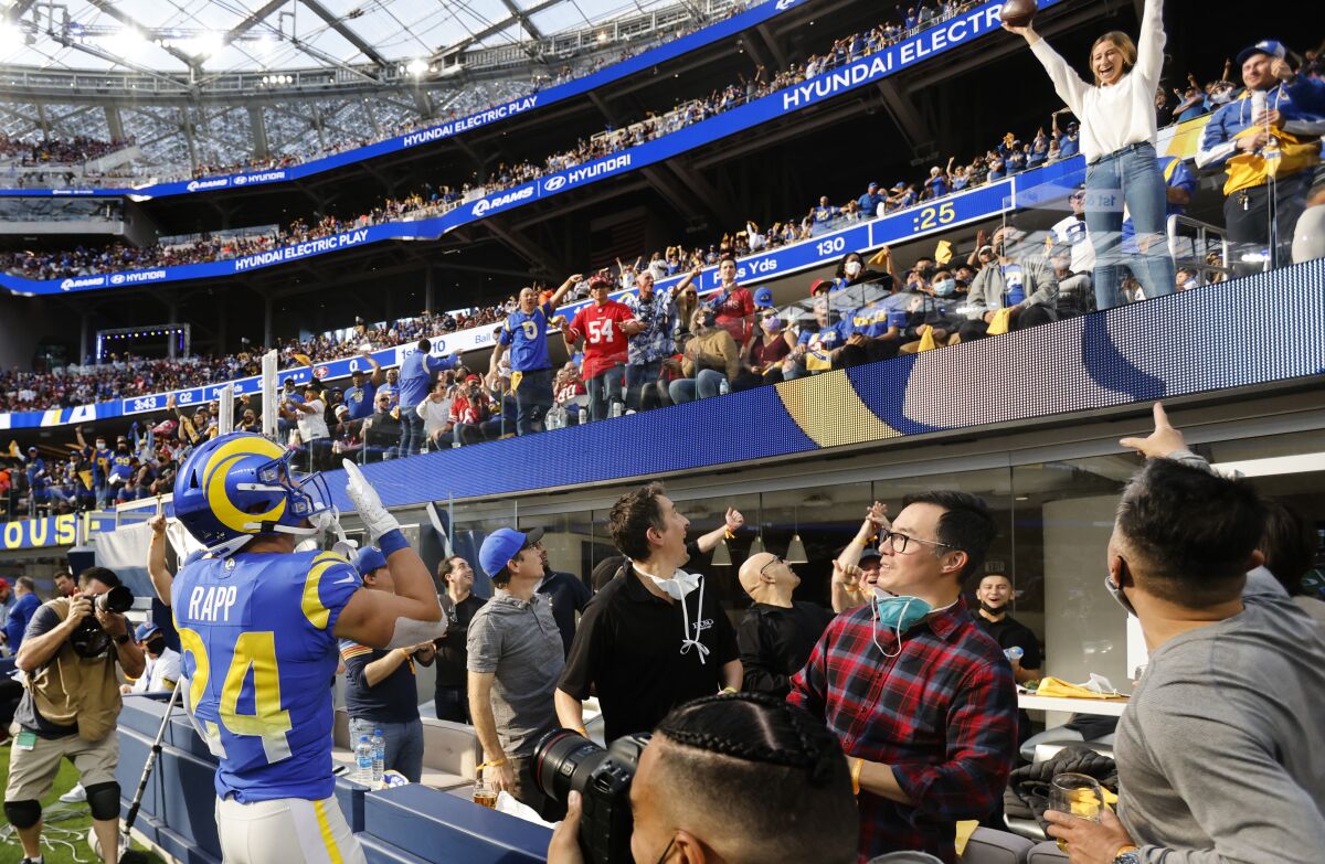 Rams free safety Taylor Rapp tosses the ball to a fan after an interception against the San Francisco 49ers.