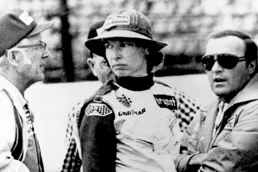 FILE - In this May 23, 1976, file photo, Janet Guthrie talks to racing car owner-builder Rolla Vollstedt, left, and A.J. Foyt, right, in the pits of the Indianapolis Motor Speedway, in Indianapolis. Janet Guthrie is still astonished at all the fan mail that pours in from around the world. And she's honored to hear that Academy Award winner Hilary Swank wants to portray her in a movie. (AP Photo/File)