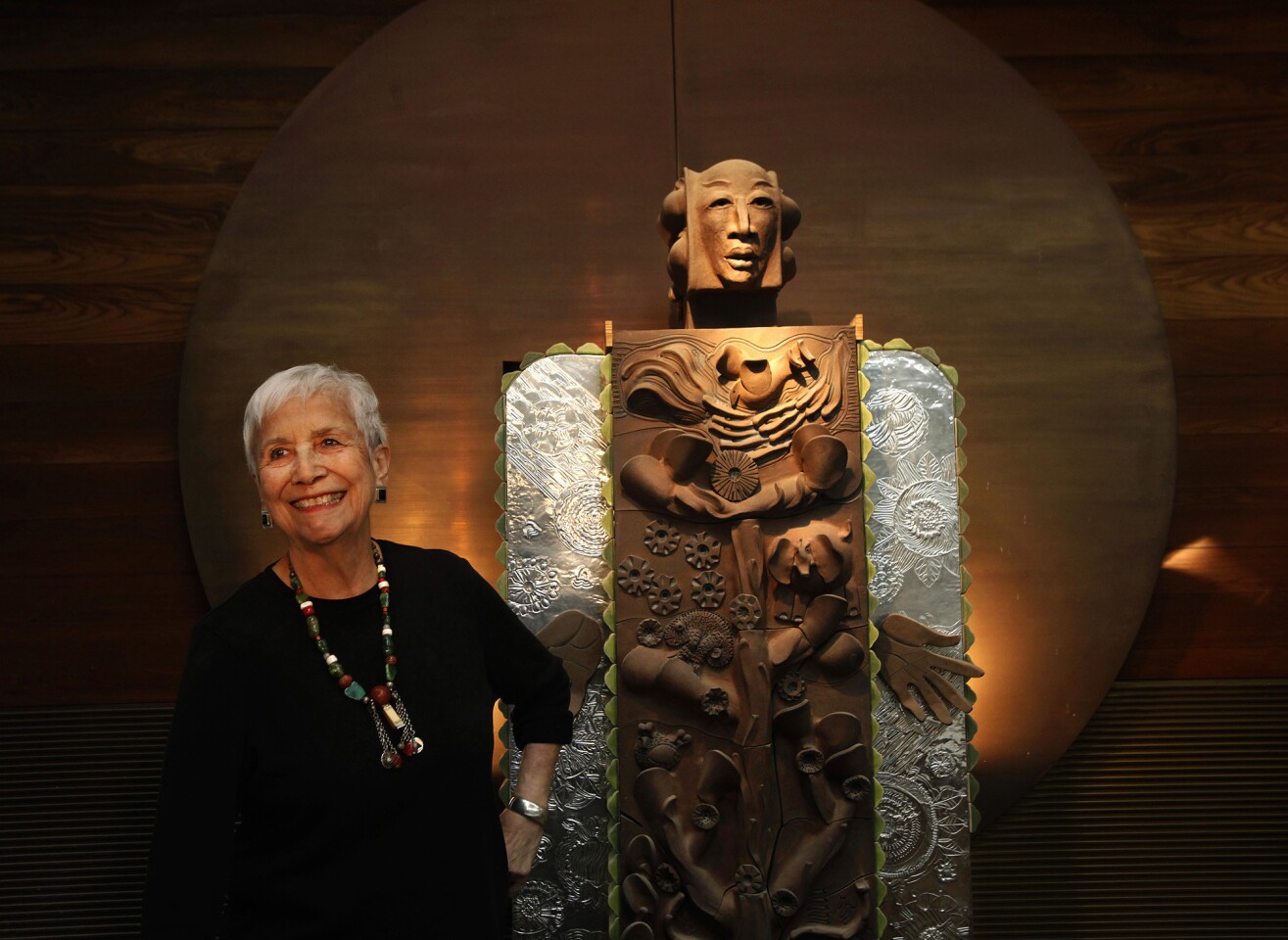 Ceramic artist Dora De Larios, 81, stands next to her piece, "Earth Goddess," at Irving Place Studio. Delarios is one of America's leading clay artists, with place settings for the White House and a grand concrete wall sculpture in Nagoya, Japan, among her accomplishments.