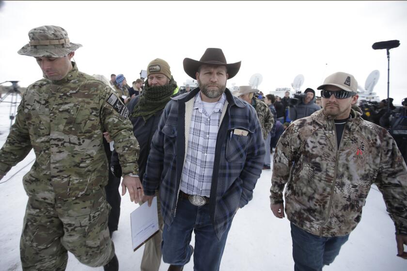 Ammon Bundy, center, one of the sons of Nevada rancher Cliven Bundy, walks off after speaking with reporters during a news conference at Oregon's Malheur National Wildlife Refuge headquarters on Jan. 4.