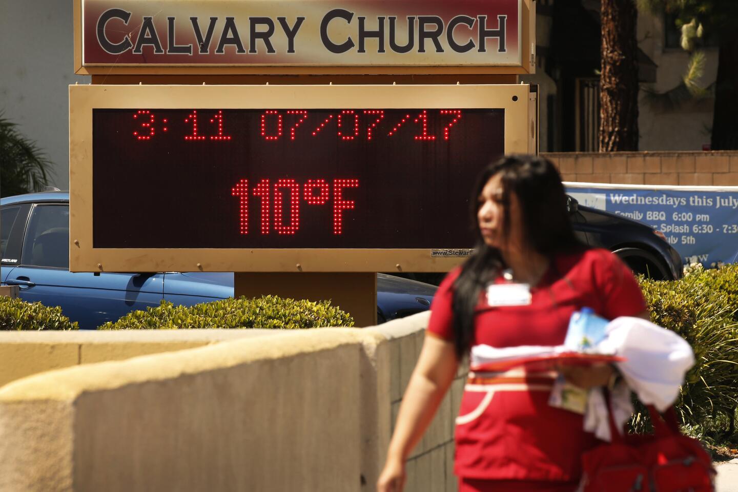 People brave record 110-degree temperatures Friday while walking to work in West Hills in the San Fe