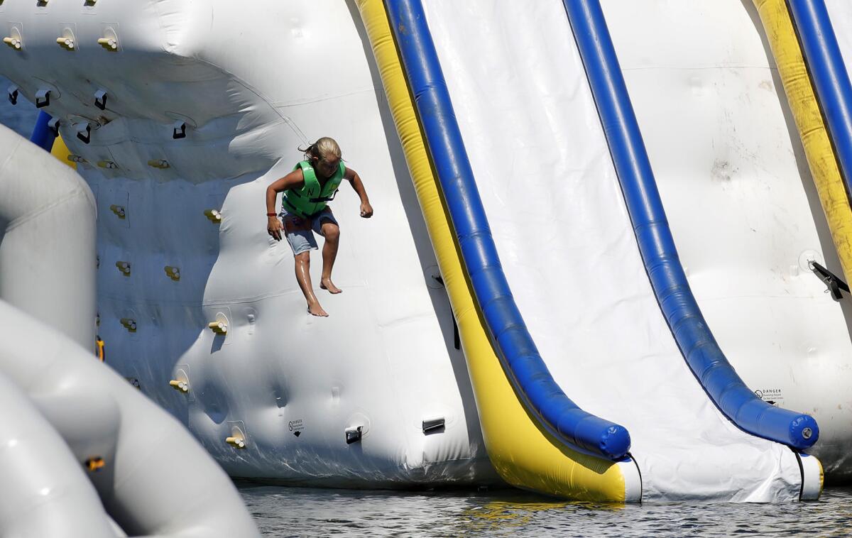 Kids enjoy a waterslide at the Newport Dunes Resort Wednesday, the second day of a heatwave that will last through Monday.