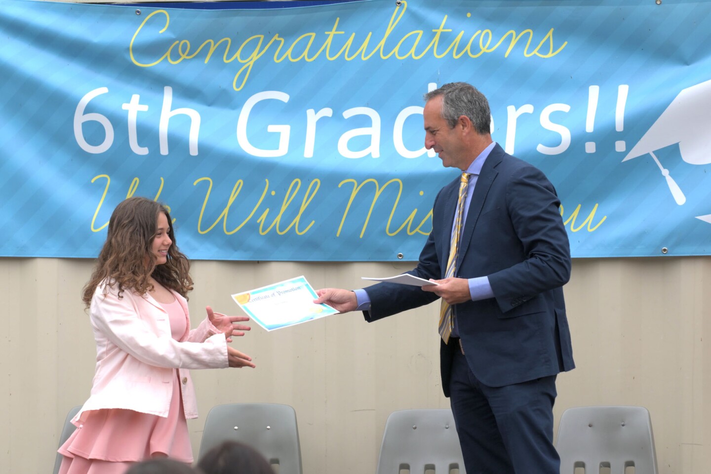 Principal Matt Frumovitz hands a Certificate of Promotion to Sara Abdou