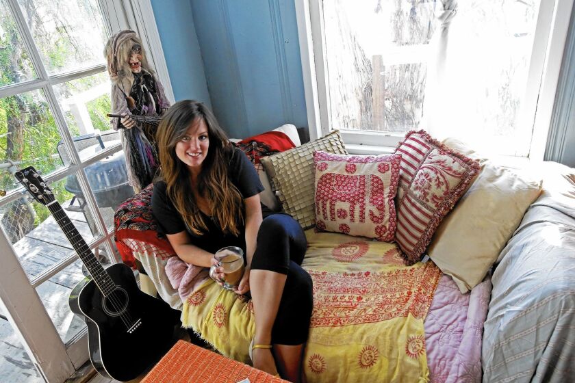 Airbnb touts “home sharing” in its ads and political campaigns, but nearly two-thirds of its listings in L.A. and other big markets are for whole units. Above, Hope Arnold is shown in 2013 on the couch she slept in when renting out her bedroom in Silver Lake.