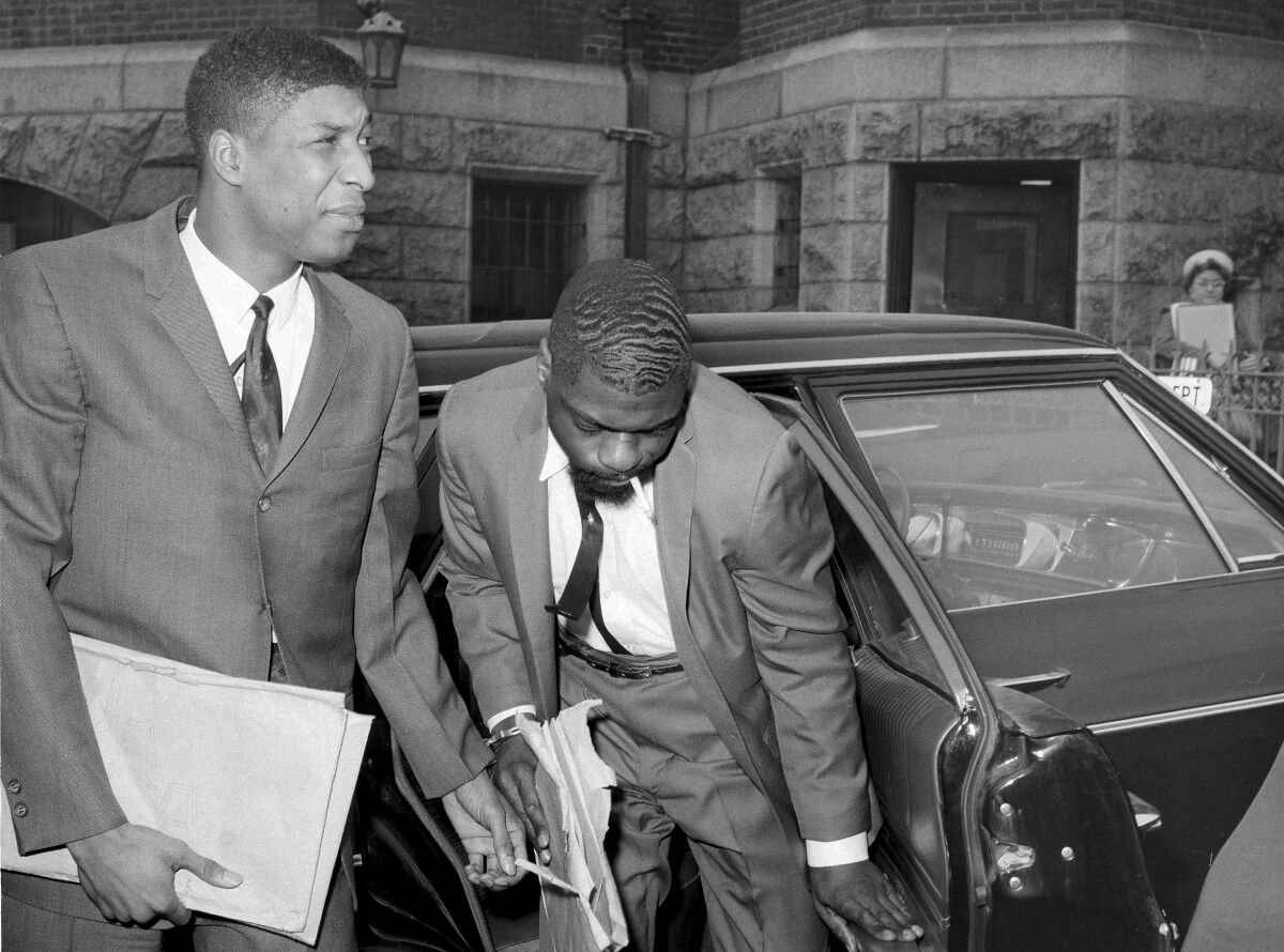 FILE - Co-defendants, from left, John Artis and Rubin "Hurricane" Carter, right, arrive at Pasaic County Courthouse Annex in Paterson, N.J., May 25, 1967. Artis, who was wrongly convicted with boxer Carter in a triple murder case that was publicized in a 1975 song by Bob Dylan and a 1999 film starring Denzel Washington, has died, Artis died at 75 on Nov. 7, 2021 of a gastric aneurysm at his home in Hampton, Va., said Fred Hogan, a longtime friend who who worked to help overturn the convictions of Artis and Carter. (AP Photo/Anthony Camerano, File)