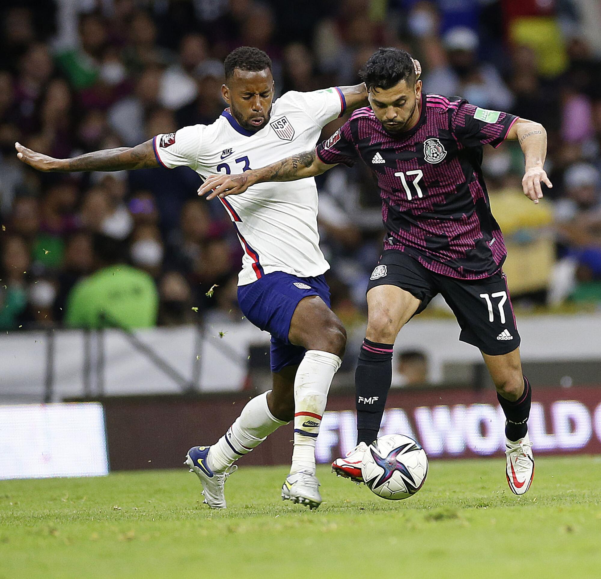 U.S. midfielder Kellyn Acosta and Mexico forward Jesus Corona battle for the ball in the first half.