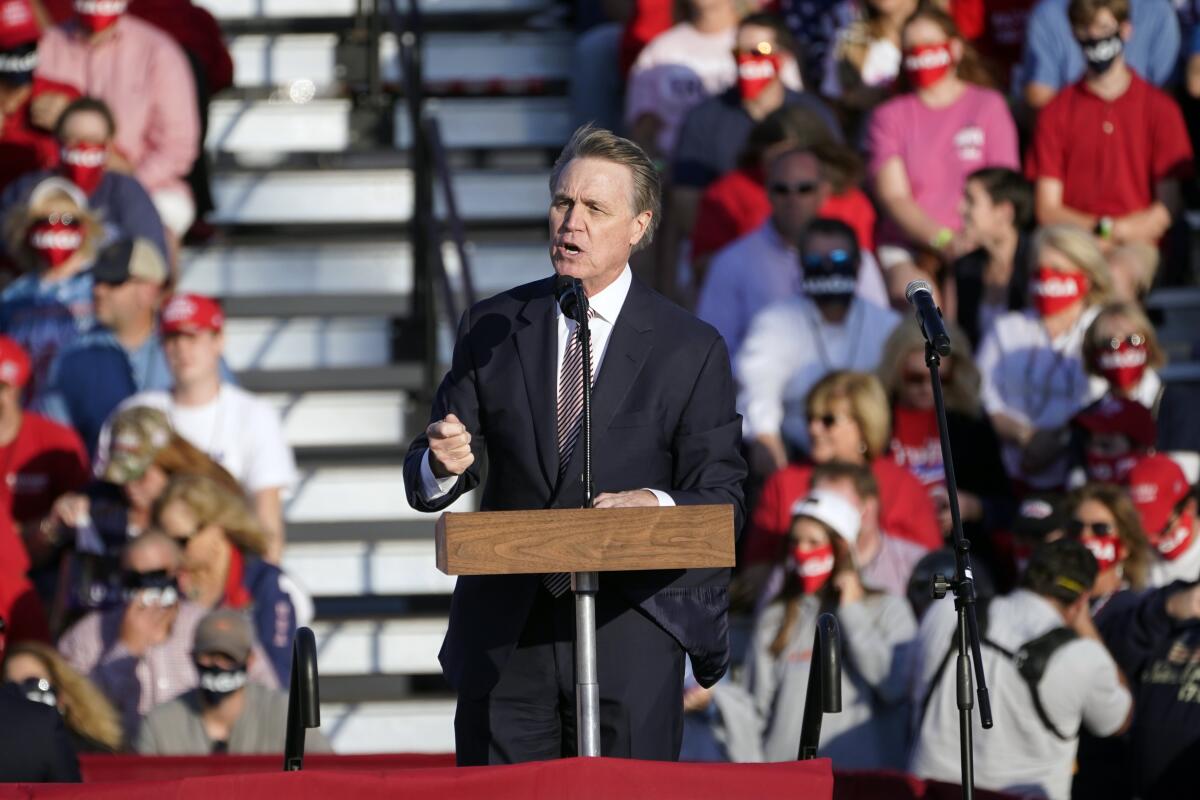 Sen. David Perdue speaks in front of a crowd at a Trump rally at Middle Georgia Regional Airport in Macon, Ga. 