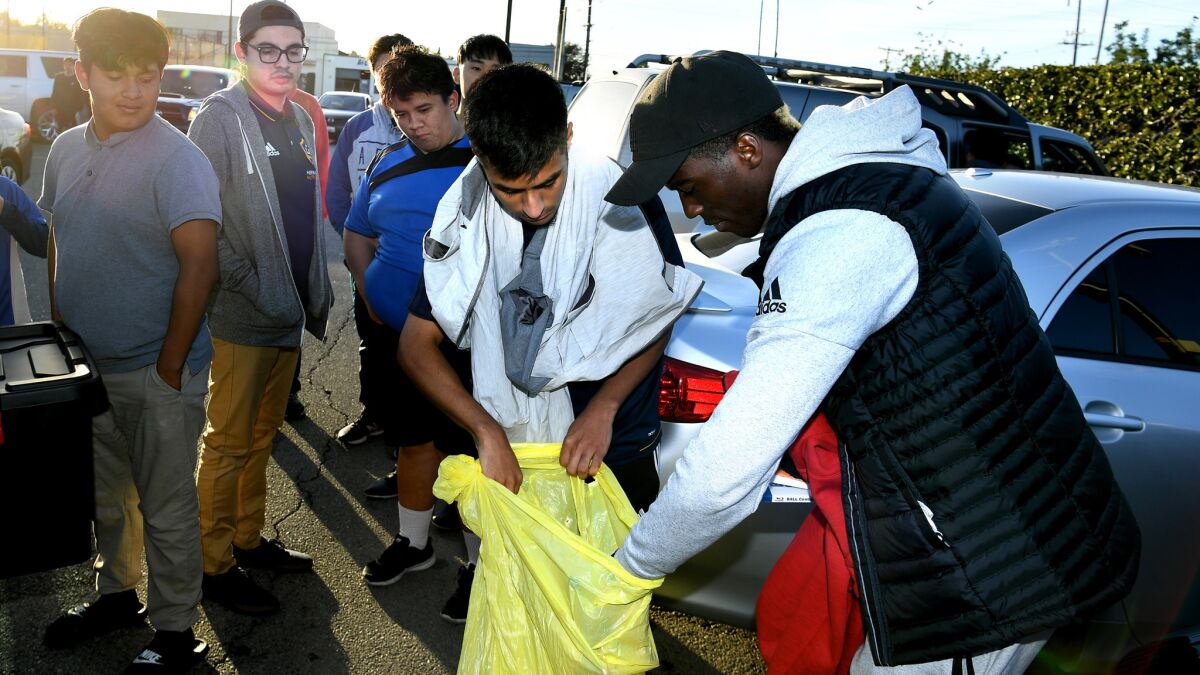 Gyasi Zardes hands out free soccer gear during a goodbye ceremony at Hawthorne Memorial Park.