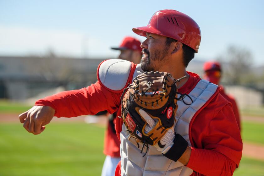 Angels catcher Kurt Suzuki warms up during a practice session at spring training in Arizona.