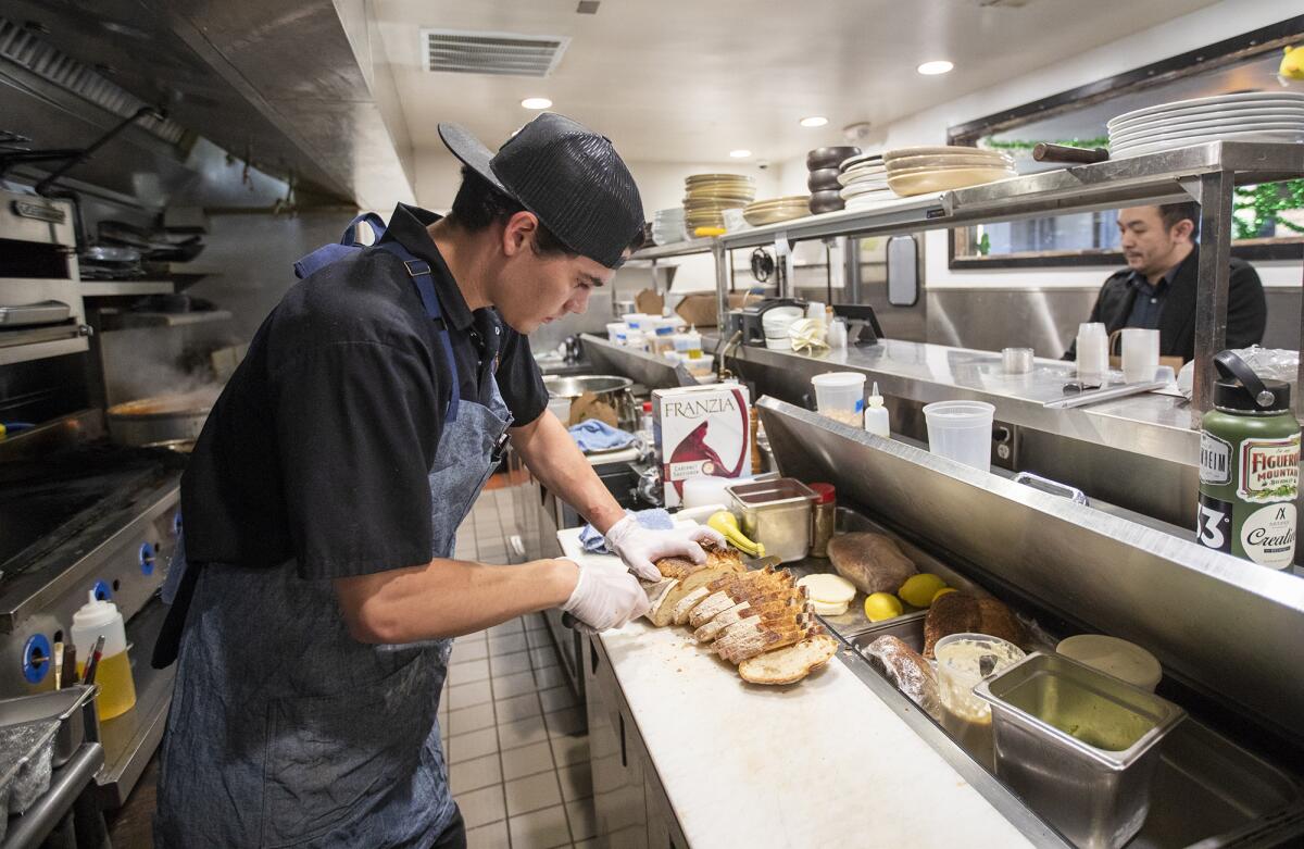 Grant Harris, executive chef of the Recess Room restaurant in Fountain Valley, prepares free grab-and-go lunches Friday for senior citizens 65 and older and students up to age 18.