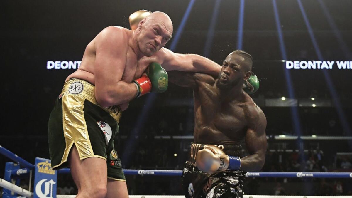 Deontay Wilder and Tyson Fury trade blows during their WBC heavyweight title fight on Dec. 1, 2018.