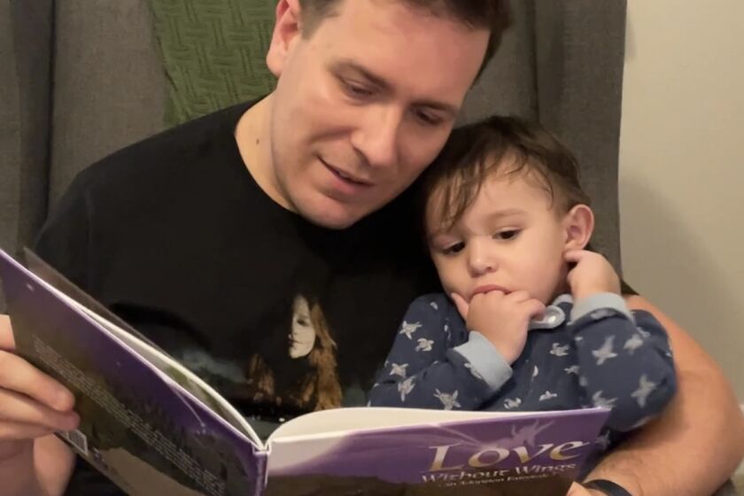 Adam Swain Ferguson reading with his son Taran.