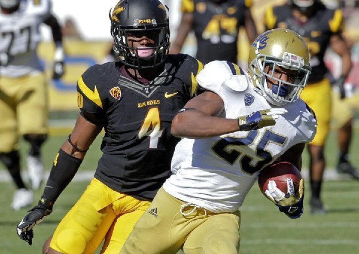 UCLA receiver Damien Thigpen pulls away from Arizona State safety Alden Darby for a scoring pass play in the second half Saturday.