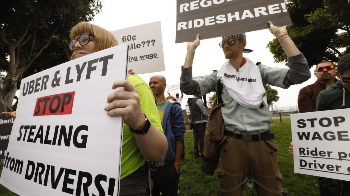 Lyft driver Jos Cashon, 28, left, joins fellow Uber and Lyft drivers during a one-day strike in protest for better wages and working conditions near Los Angeles International Airport in May.