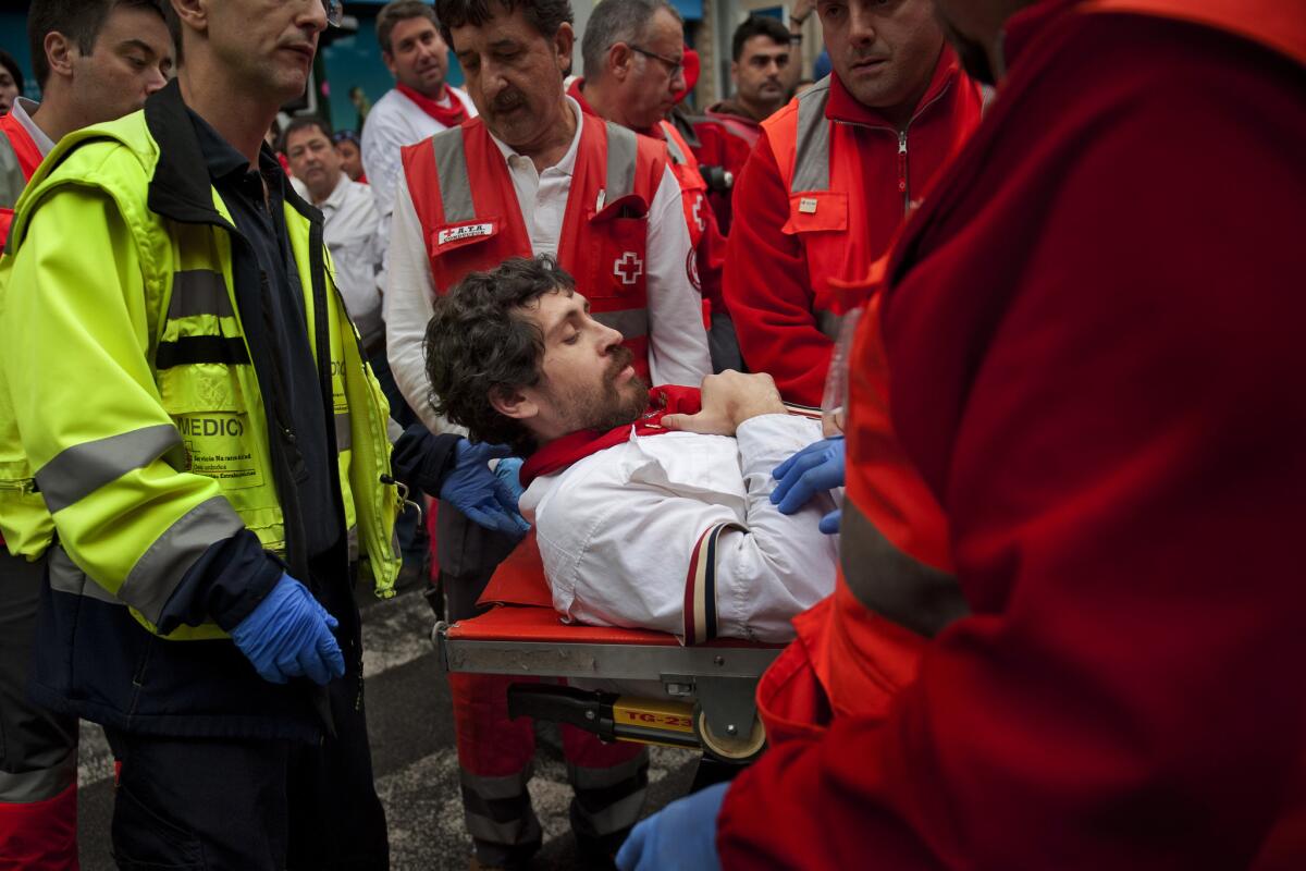 American author Bill Hillmann is carried on a stretcher after being gored in his right thigh during the running of the bulls in Pamplona, Spain, on Wednesday.