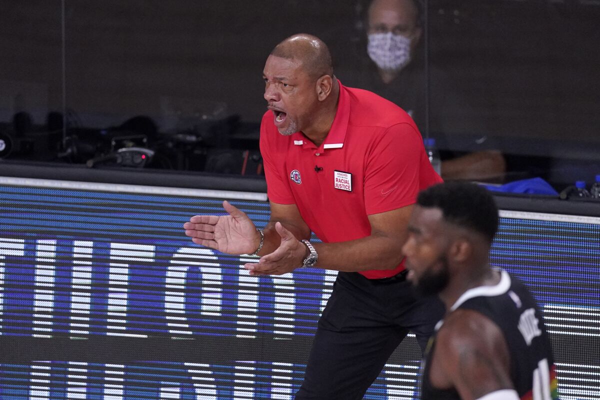 Clippers coach Doc Rivers claps during a game.