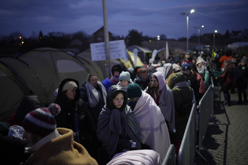 FILE - Refugees fleeing war in neighboring Ukraine queue at the Medyka border crossing, Poland, March 10, 2022. Around 2.5 million people have fled Ukraine in the two weeks since Russia invaded. Most have fled to the European Union. (AP Photo/Daniel Cole, File)