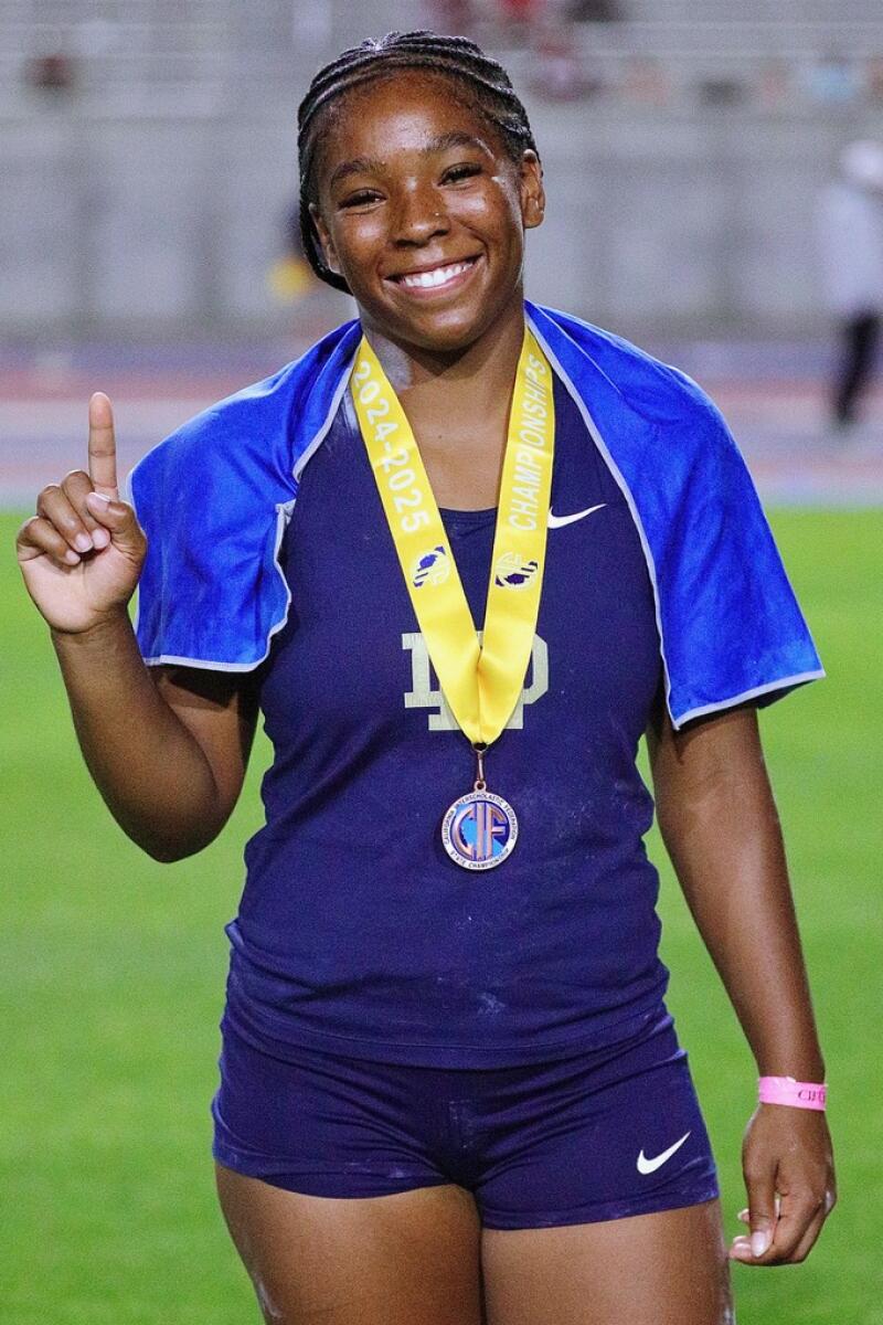 Sherman Oaks Notre Dame's Aja Johnson celebrates after finishing first in the girls' shot put on Saturday.