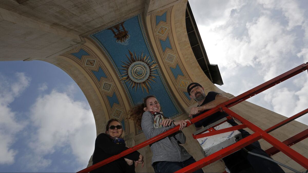 Thanks to the work of a young sleuth, restoration artists Aneta Zebala, left, Suzanne Morris and Adam Romcio gained important information about the Coliseum's mural.
