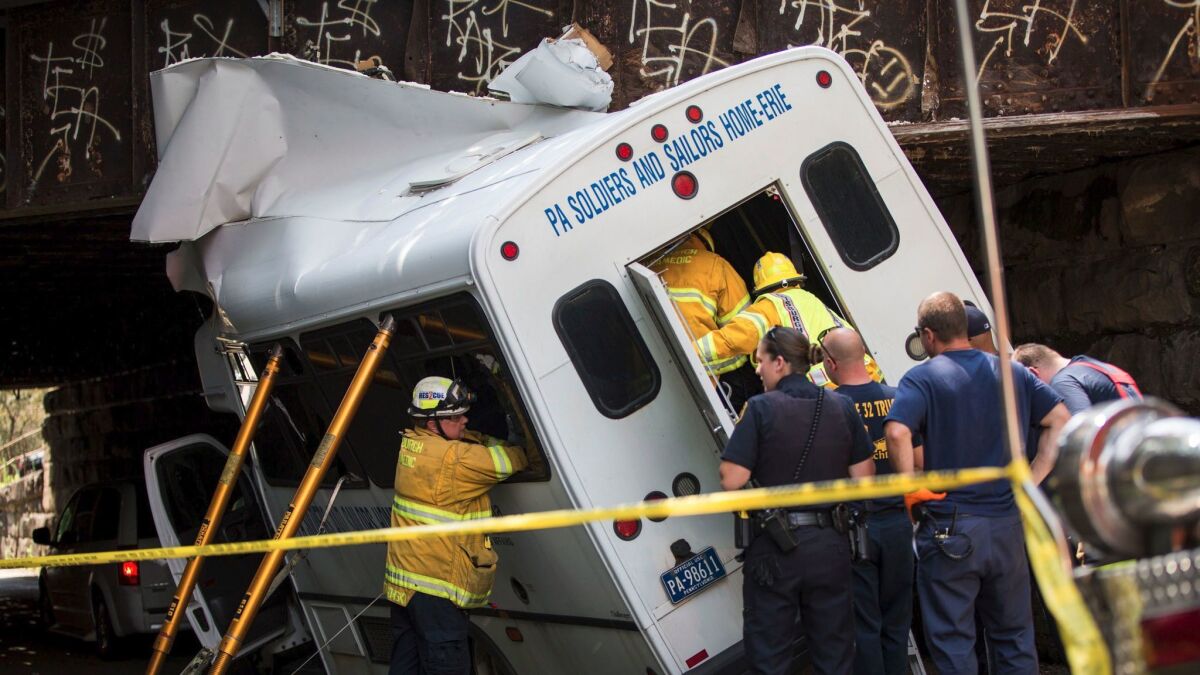 Rescue workers help remove passengers from a bus that crashed into an overpass in Pittsburgh on July 20.