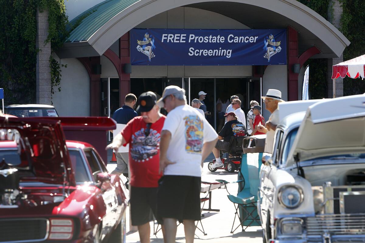 Men check out classic cars during the 2022 Cruisin' for a Cure car show at the O.C. fairgrounds.