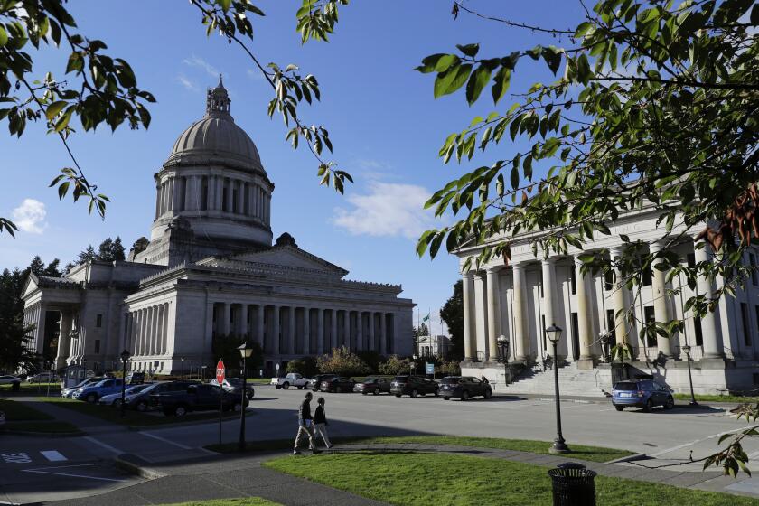 FILE - The afternoon sun illuminates the Legislative Building, left, at the Capitol in Olympia, Wash, Oct. 9, 2018. The Washington state House has overwhelmingly approved legislation that would ban police from hog-tying suspects, a restraint technique that has long drawn concern due to the risk of suffocation. The vote on Wednesday, Feb. 28, 2024 came nearly four years after Manuel Ellis, a 33-year-old Black man, died in Tacoma, Washington, facedown with his hands and feet cuffed together behind him. (AP Photo/Ted S. Warren, File)