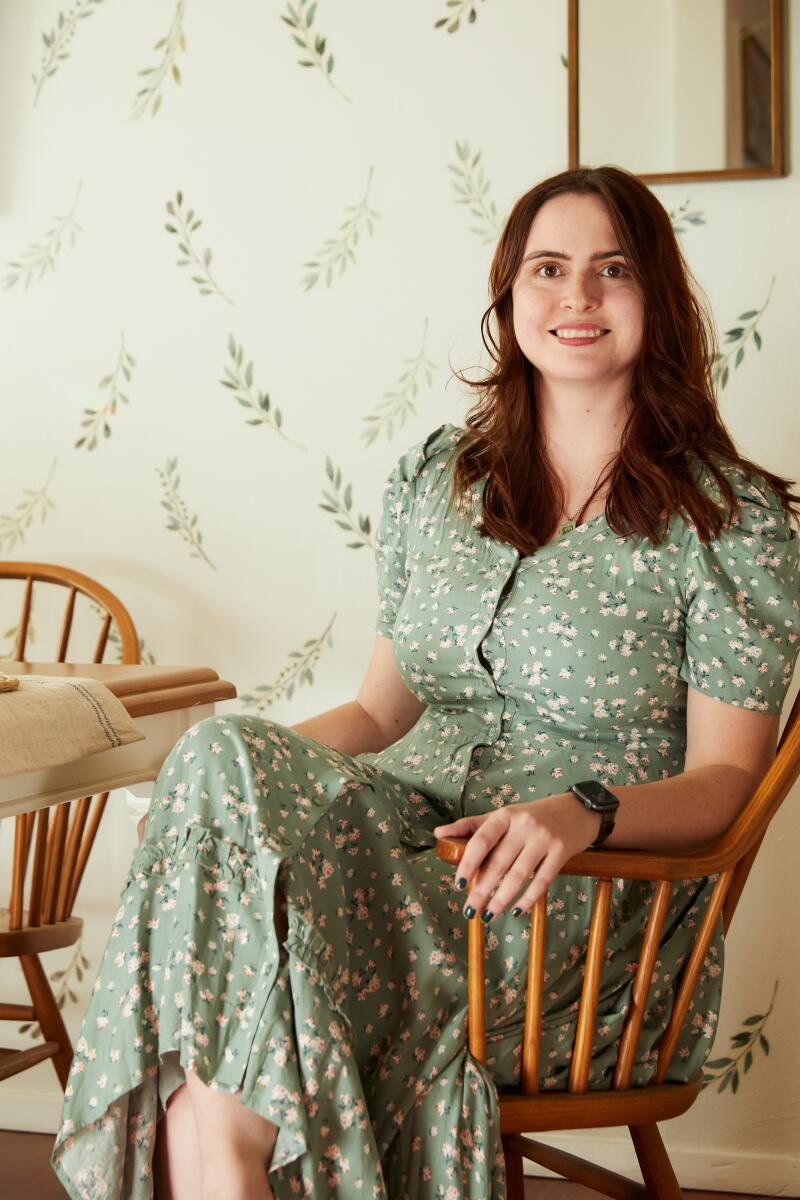Catie Brown sits at her dining room table in her apartment