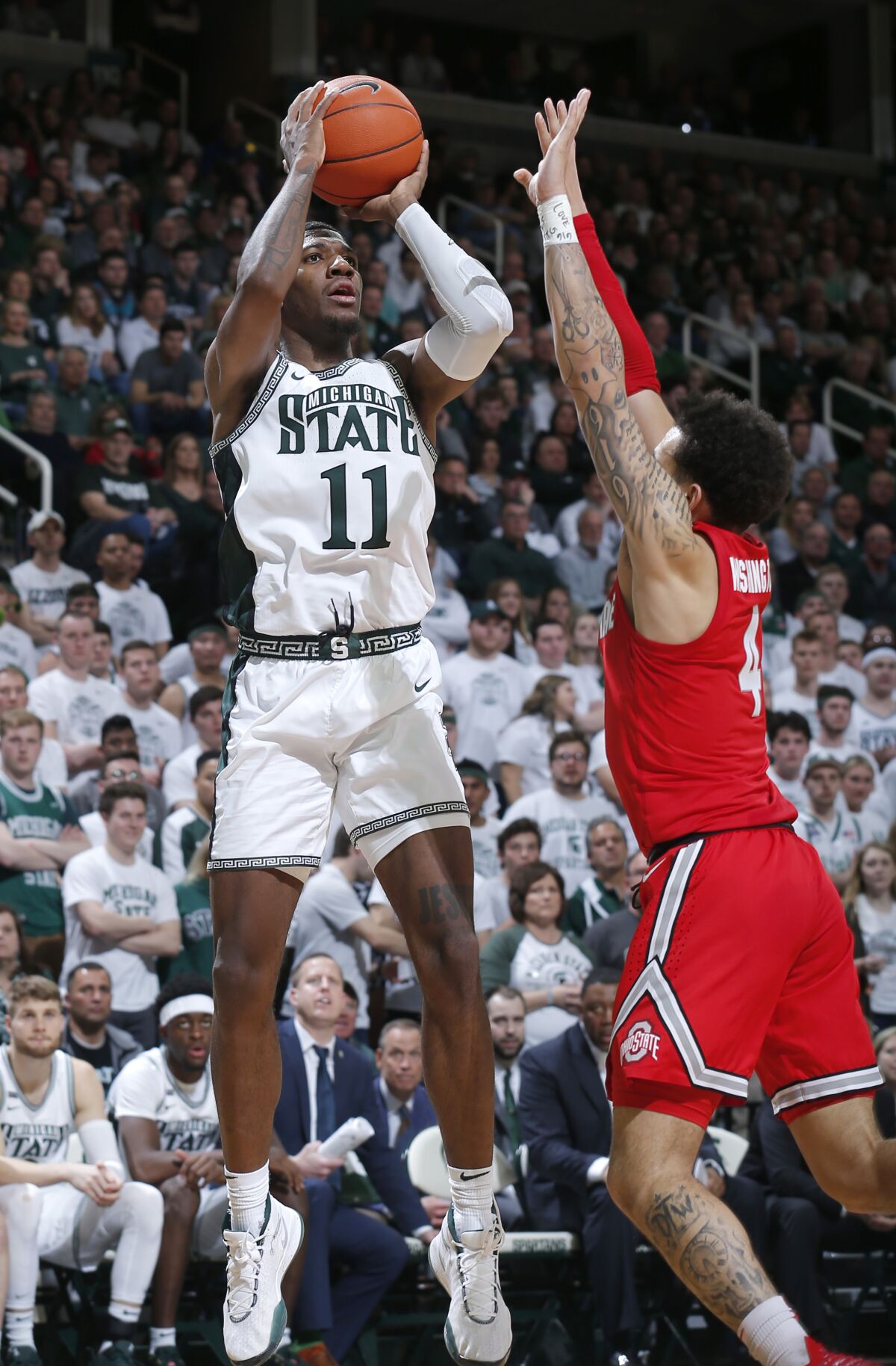 FILE - Michigan State's Aaron Henry, left, shoots against Ohio State's Duane Washington Jr. during the second half of an NCAA college basketball game in East Lansing, Mich., in this Sunday, March 8, 2020, file photo. Michigan State won 80-69. The team will need preseason All-Big Ten player Aaron Henry to produce much more than he has in the past as a role player.(AP Photo/Al Goldis, File)