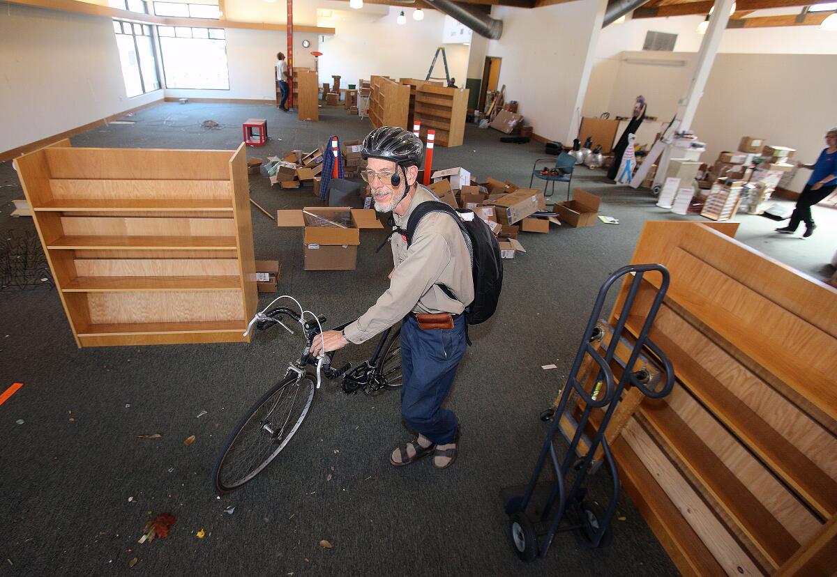 Flintridge Bookstore owner Peter Wannier, on the emptying floor room of his old bookstore location at 1010 Foothill Blvd., gathers his bicycle to ride to his new location in La Cañada Flintridge on Tuesday, March 3, 2020.