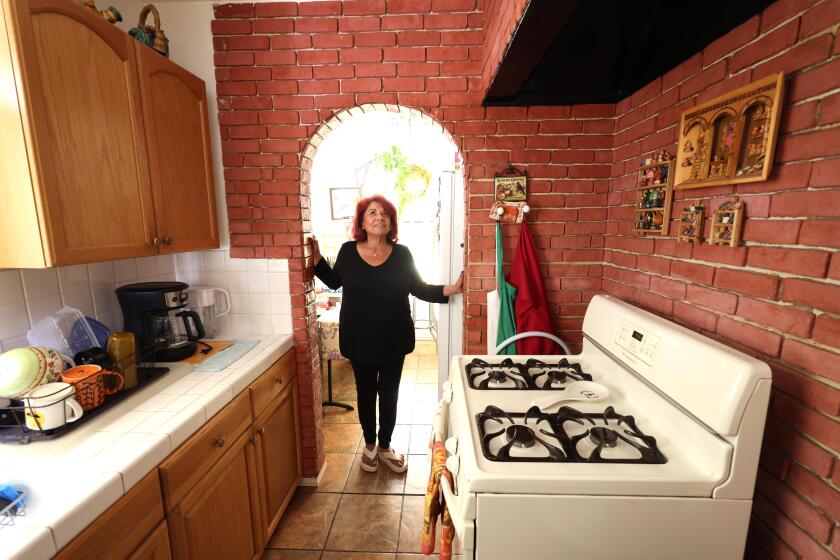 EL SERENO, CA - AUGUST 31, 2024 - Patricia Payan, 77, casts a hopeful glance over the kitchen of the Caltrans-owned home she has rented since 1986 in El Sereno on August 31, 2024. Payan's now in escrow to purchase it for around $70,000. Payan is overjoyed at the chance to own the home where she raised her family and leave it to her children and grandchildren. (Genaro Molina/Los Angeles Times)