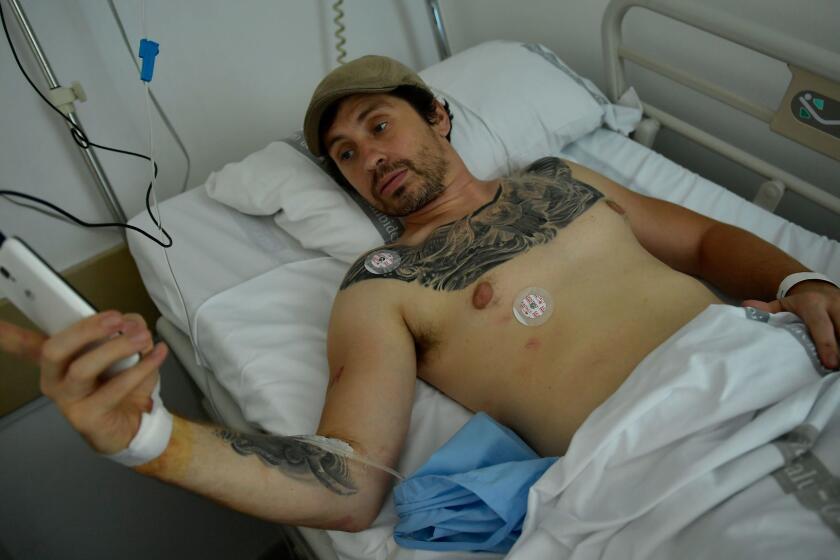 Bill Hillmann, 35-year-old American from Chicago lies in a hospital bed after being gored at the San Fermin bull running Festival, in Pamplona, northern Spain, Saturday, July 8, 2017. Hillmann was in stable condition after televised images showed a bull thrusting its horn into a man's buttocks before flipping him into the street. Two Americans were gored and several other people were injured Saturday during the second running of the bulls at this year's San Fermin festival in the northern Spanish city of Pamplona, officials said.(AP Photo/Alvaro Barrientos)
