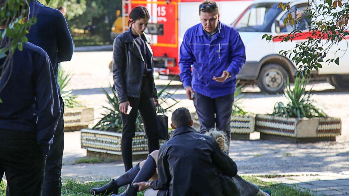 A man holds an injured victim of an attack at a college in the city of Kerch in Crimea on Wednesday.
